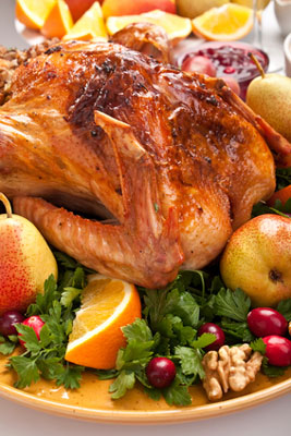 roast turkey with vegetables and fruit on a platter
