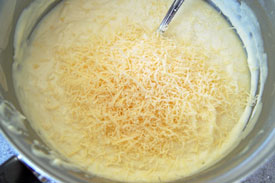 adding parmesan cheese to white sauce
