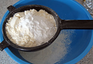 sifting flour for lemon muffins